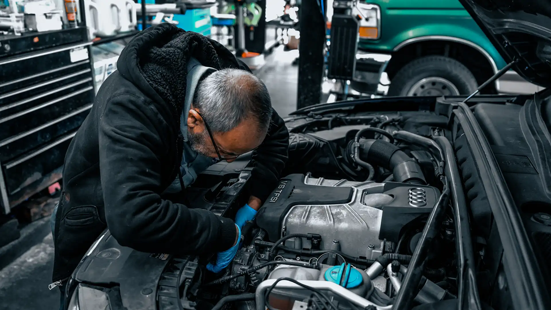 Car engine mechanic diagnosing engine and elictrical problems